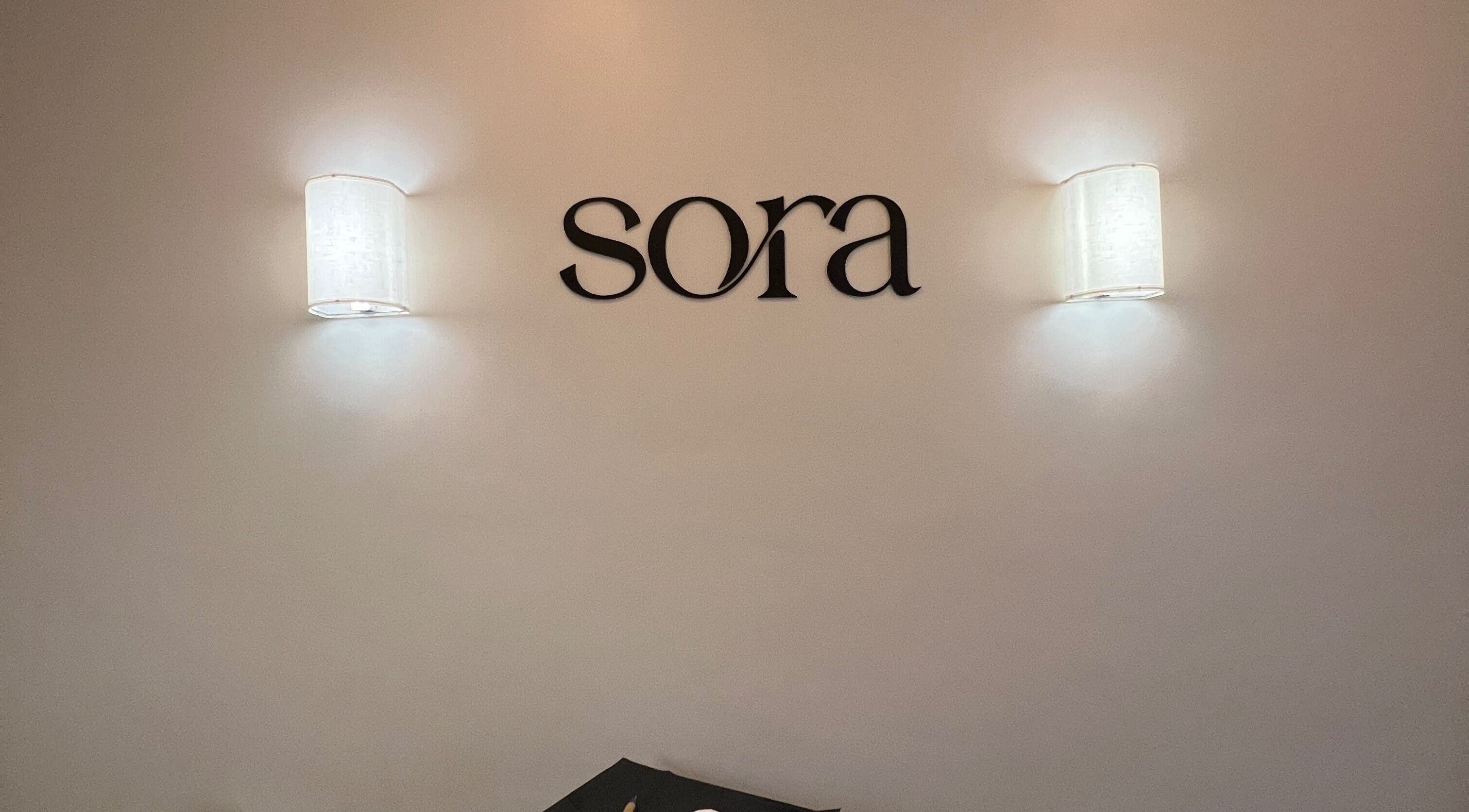 Elegant wall lights and Sora logo at Cole Bay, SX beauty and wellness venue.