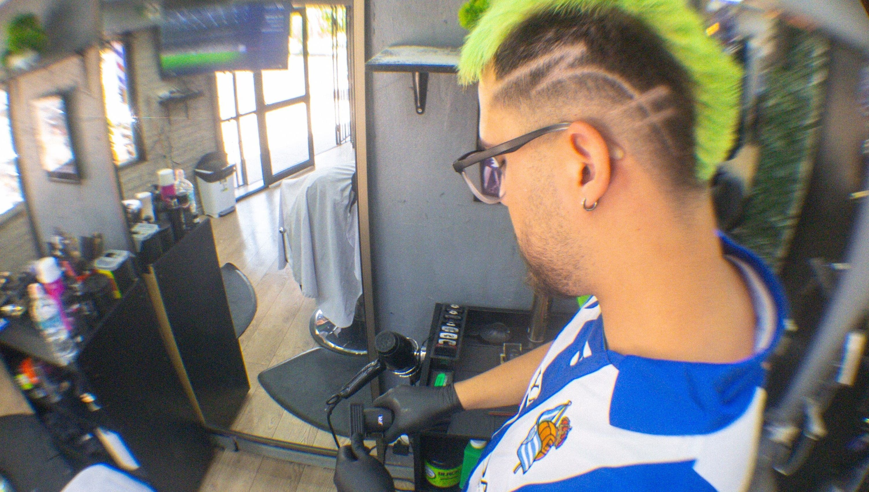 Barbero estilizando cabello verde y decorado en Ramses barber, Peñalolén, Región Metropolitana, CL.
