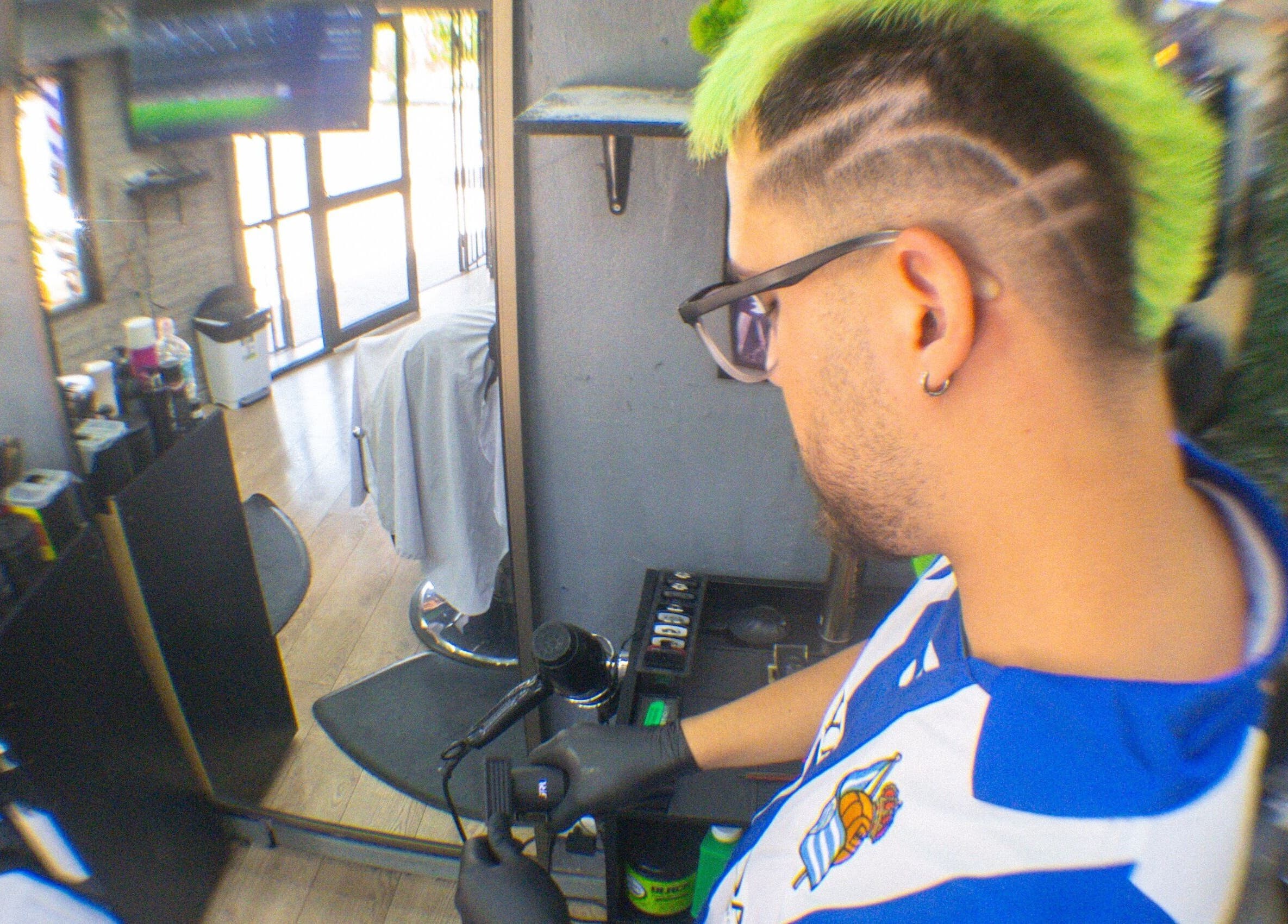 Barbero estilizando cabello verde y decorado en Ramses barber, Peñalolén, Región Metropolitana, CL.