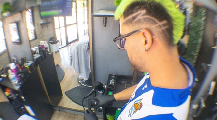 Barbero estilizando cabello en Ramses Barber, Peñalolén, Región Metropolitana, CL. Interior moderno y detallado.