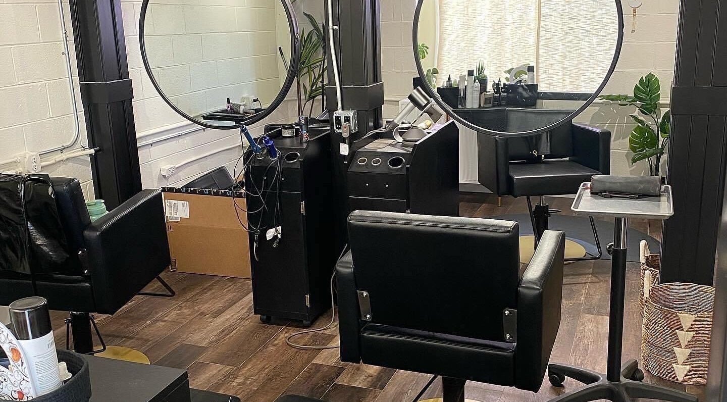 Modern salon interior at Tristen Graves, Ridgefield, Washington, US, featuring sleek black chairs and mirrors.