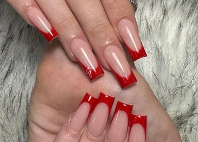 Red French manicure by The Nail Boutique, Hersham, England, GB. Chic nail art on plush fur background.