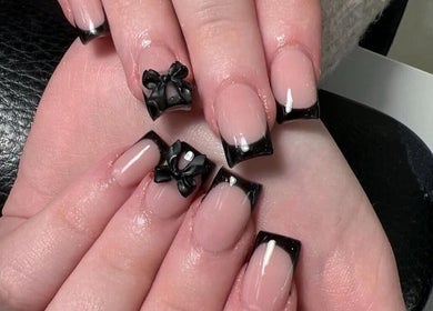 Elegant French manicure with black bows at The Nail Boutique, Hersham, England, GB.