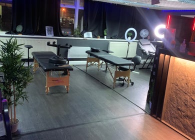 Warm, inviting interior of MJ ink tattoos in Barking, England, with tattoo chairs and serene lighting.