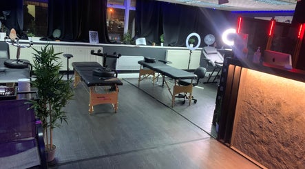Warm, inviting interior of MJ ink tattoos in Barking, England, with tattoo chairs and serene lighting.