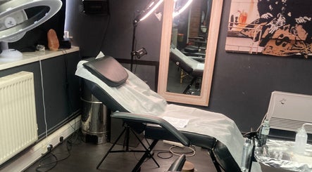 Modern tattoo studio interior at MJ ink tattoos in Barking, England, GB featuring a comfortable chair and mirror.
