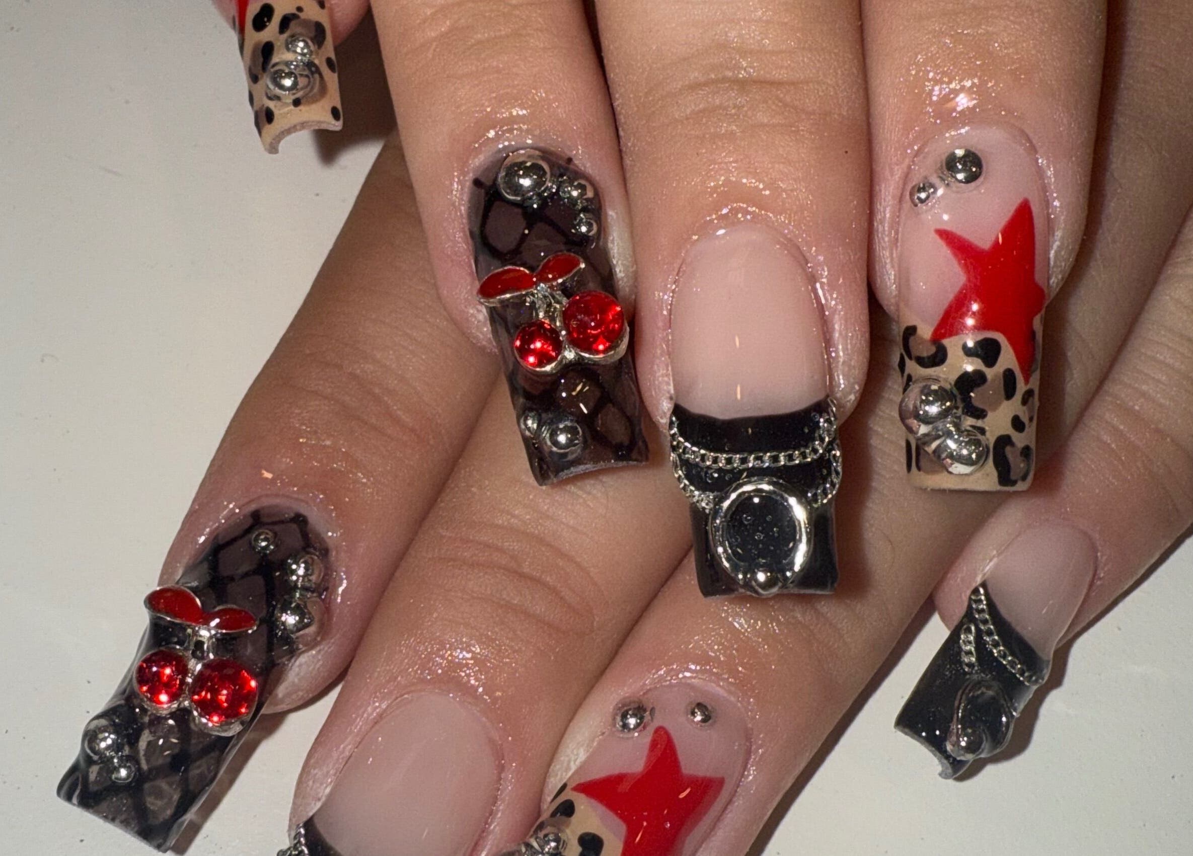 Stylish 3D nail art at Squid Nails in Coquitlam, British Columbia, CA showcasing bold red and black designs.