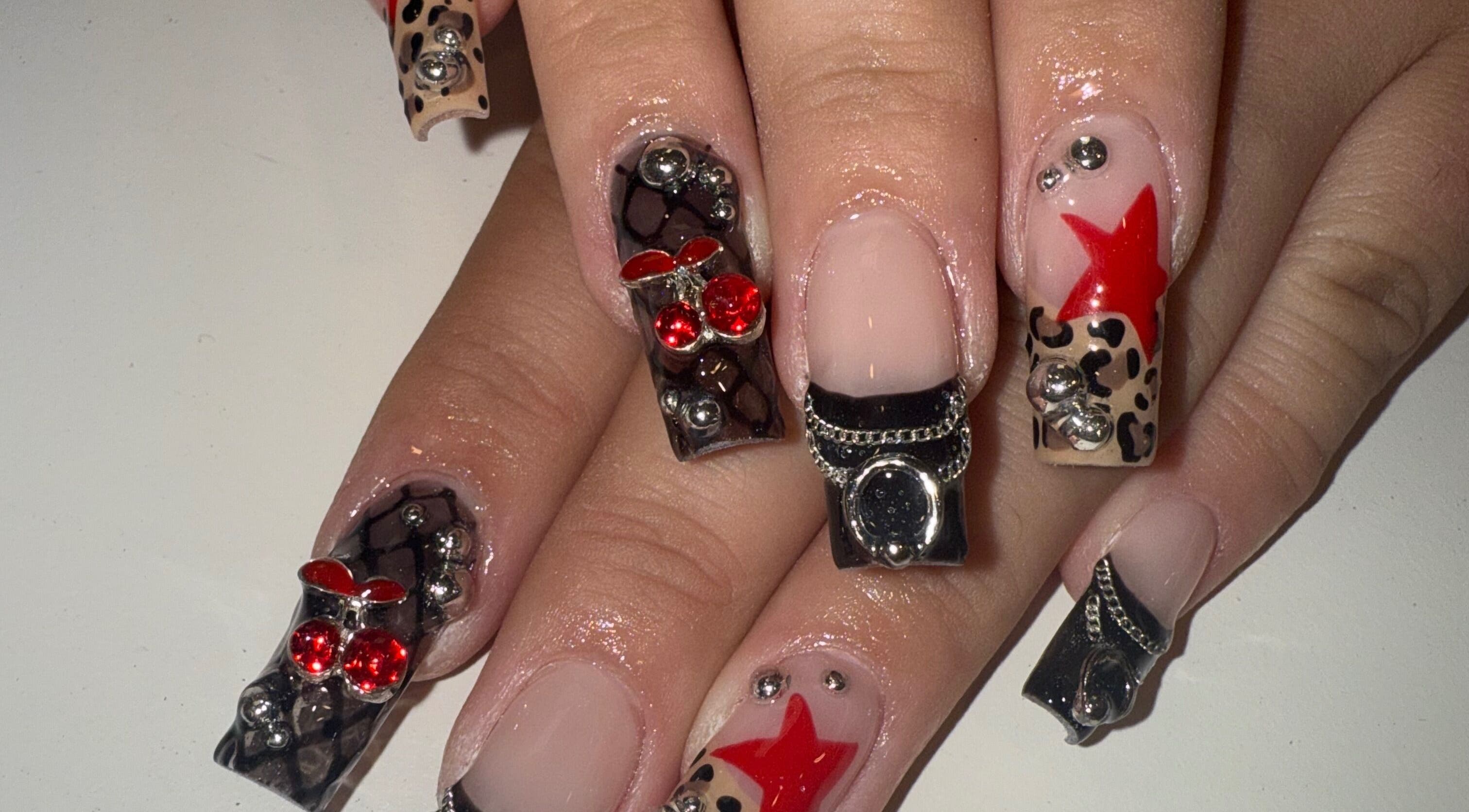 Stylish 3D nail art at Squid Nails in Coquitlam, British Columbia, CA showcasing bold red and black designs.