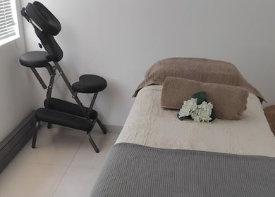 Massage room at Clarify wellness spa, Johannesburg, Gauteng, ZA with a comfy bed and massage chair.