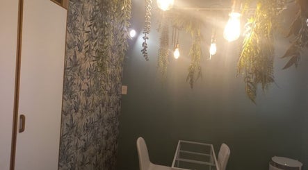 A tranquil spa room at Radiant Grace Wellness & Beauty Bar, Mossel Bay, Western Cape, ZA with hanging greenery.