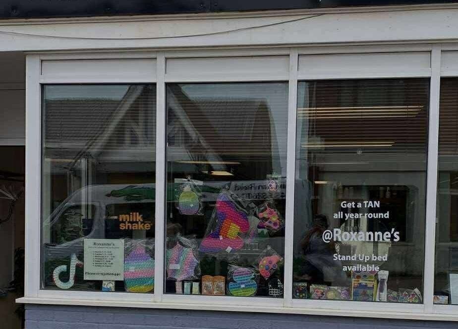 Street view of CaraEvans_Hair salon in Milford Haven, Wales, GB showcasing colorful product displays.