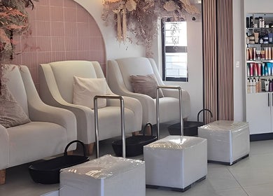 Elegant pedicure chairs in Blush Aesthetics & Beauty Bar, Cape Town, Western Cape, ZA, surrounded by beauty products.