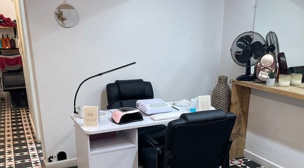 Modern manicure station at Ella’s Beauty Lounge, Briercliffe, England, GB, featuring sleek black chairs and nail tools.