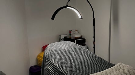Cozy treatment room at Ella’s Beauty Lounge, Briercliffe, England, GB, featuring soft lighting and plush bedding.