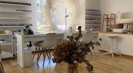 Interior luminoso y elegante de Laine Favaro Estetica y Bienestar en Vigo, ES, destacando mesas de manicura.