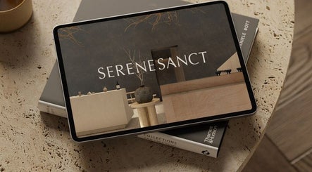 Tablet showing SereneSanct Massage & Spa's sleek design, Phuket, TH, resting on a textured surface.
