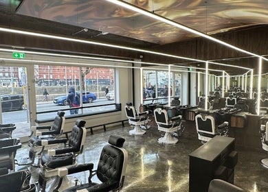 Interior da barbearia em Hairstyles Victor Estefen, Dublin, County Dublin, IE, com cadeiras de couro elegantes.