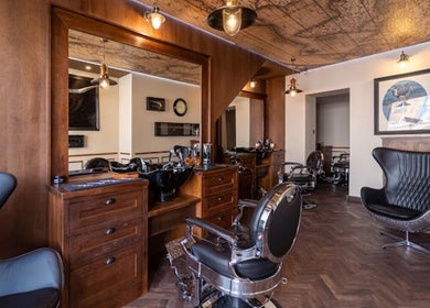 Interior sofisticado da Cult Barber Malahaide em Malahide, County Dublin, IE, com cadeiras de barbeiro modernas.
