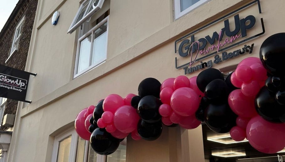 Front entrance of Glow Up Tanning & Beauty Downham, Downham Market, England, GB, with pink and black balloons.