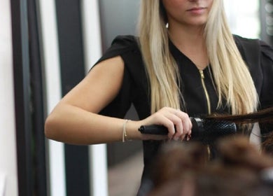 Hair stylist blow-drying client at Glow Up Tanning & Beauty Downham in Downham Market, England, GB.