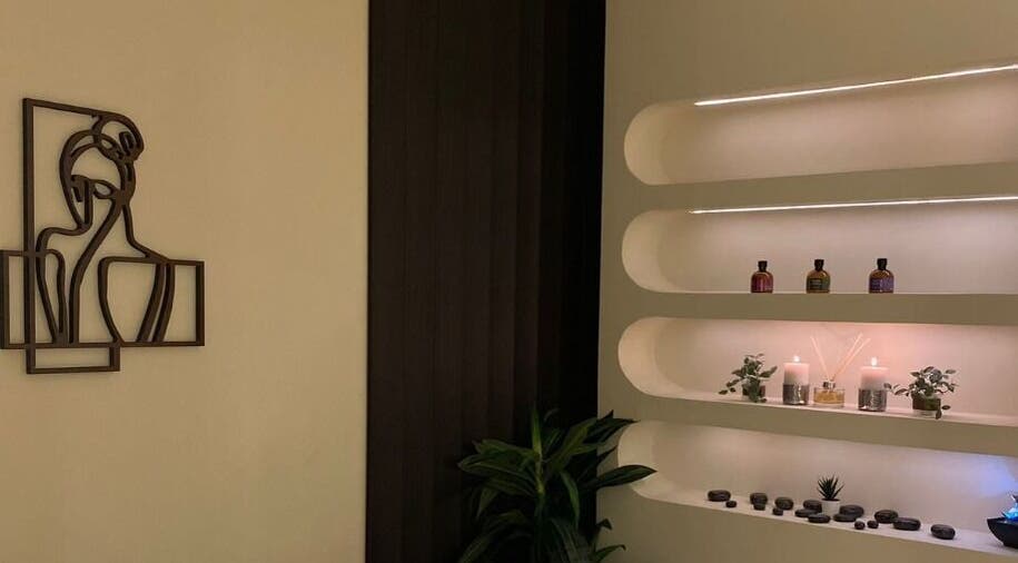 زاوية الاسترخاء في Shea Salon Spa & Beauty، مكة، تحقق تجربة هادئة مع الشموع والنباتات في أرفف جمالية.