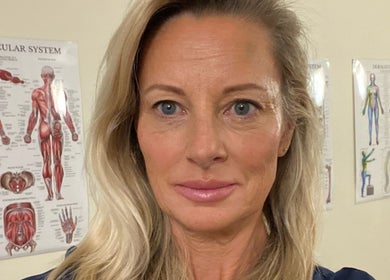 A wellness expert at Glo & Co, Wallingford, England, GB, with anatomical charts in the background.