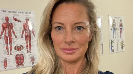 A wellness expert at Glo & Co, Wallingford, England, GB, with anatomical charts in the background.