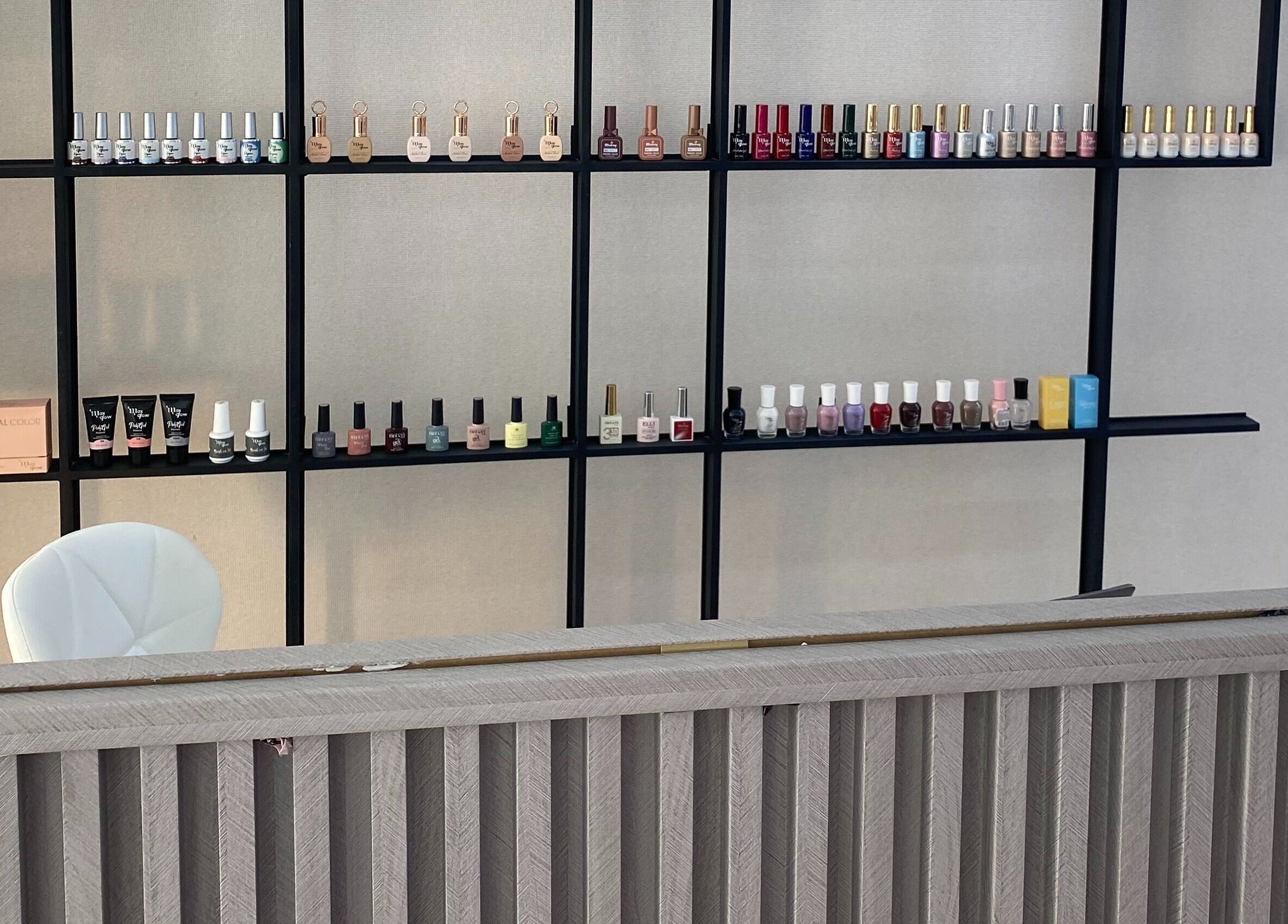 Estante de esmaltes en Anaya Beauty Bar, Valencia, Carabobo, VE, mostrando colorida variedad.
