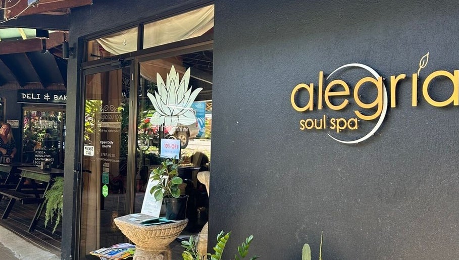 Entrance of Alegria Soul Spa in Puntarenas Province, CR, featuring stylish signage and leafy decor.