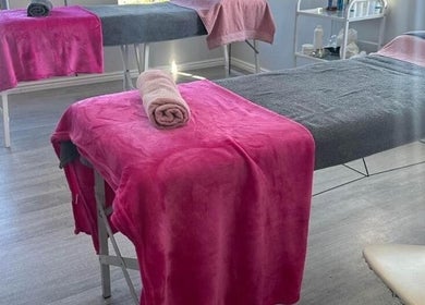 Massage beds at Skin and Body Fitness Table View, Cape Town, Western Cape, ZA with pink and grey linens.