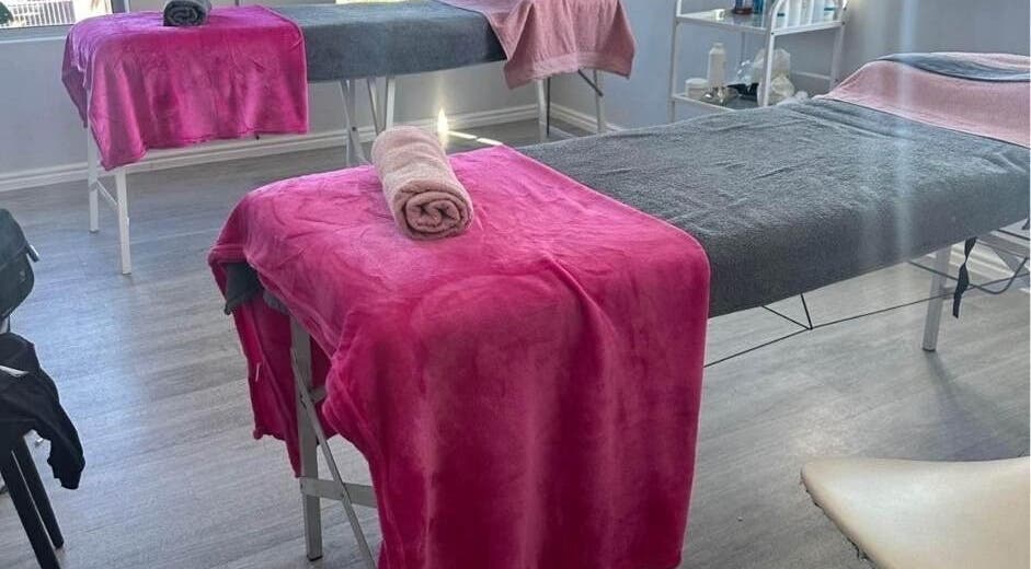 Massage beds at Skin and Body Fitness Table View, Cape Town, Western Cape, ZA with pink and grey linens.