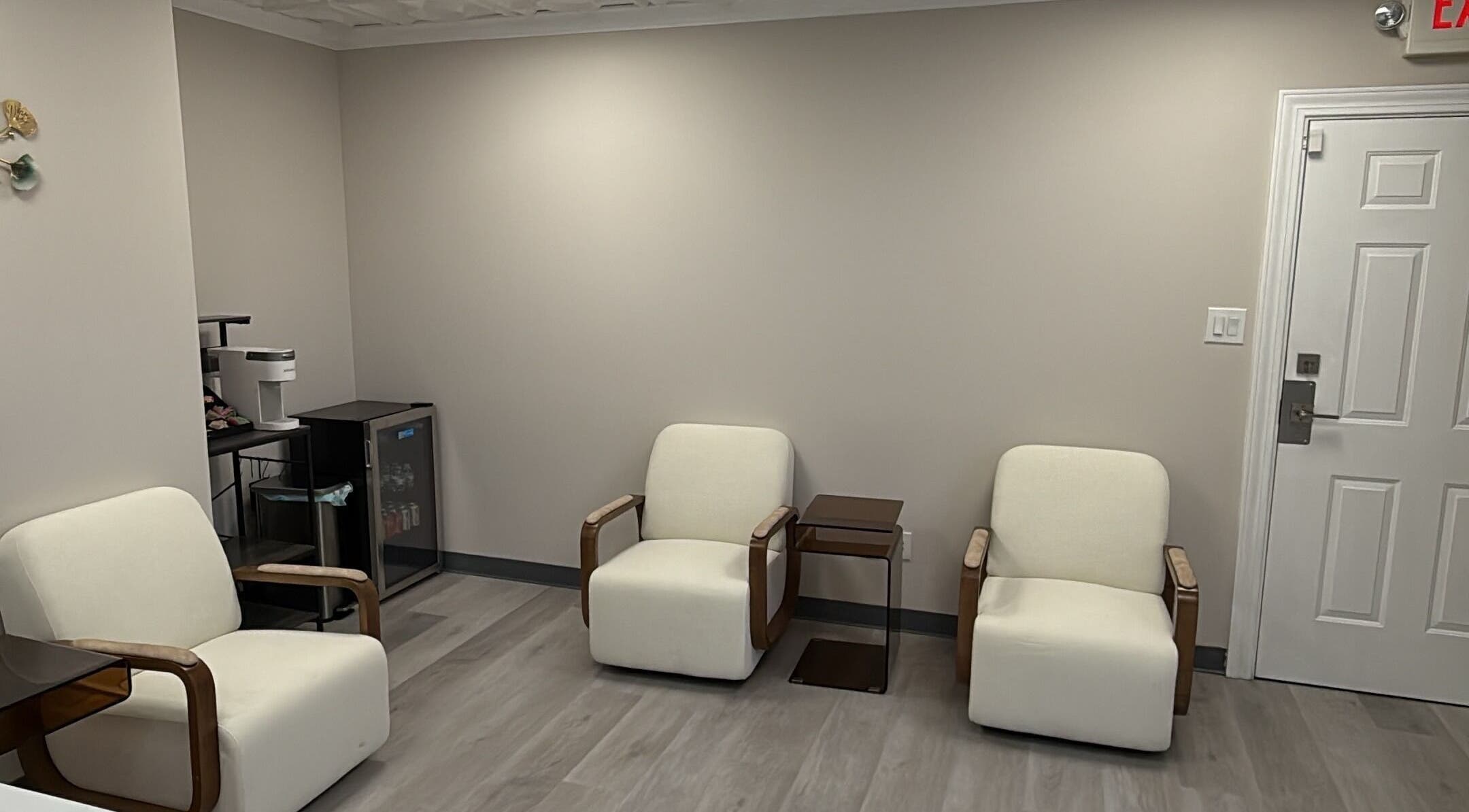 Cozy waiting area at YouShine Medspa in Douglass Hills, Kentucky, US with modern cream chairs and minimal decor.