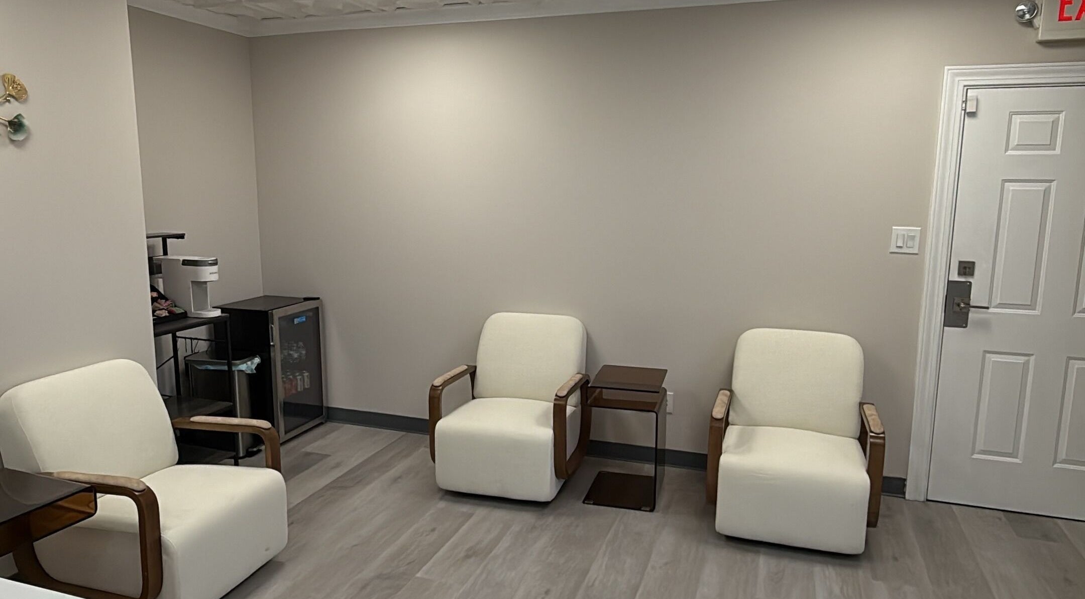 Cozy waiting area at YouShine Medspa in Douglass Hills, Kentucky, US with modern cream chairs and minimal decor.