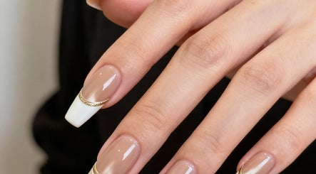 Elegant nail design with white tips and gold accents at Beauty By Holiday, Long Branch, New Jersey, US.