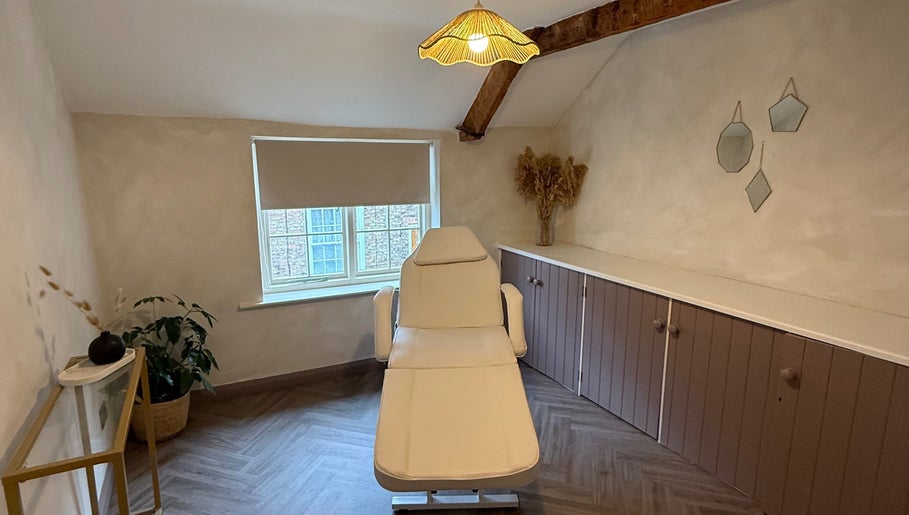 Relaxing treatment room at Bare and Glow Skin, Thirsk, England, GB with a cozy chair and natural decor.