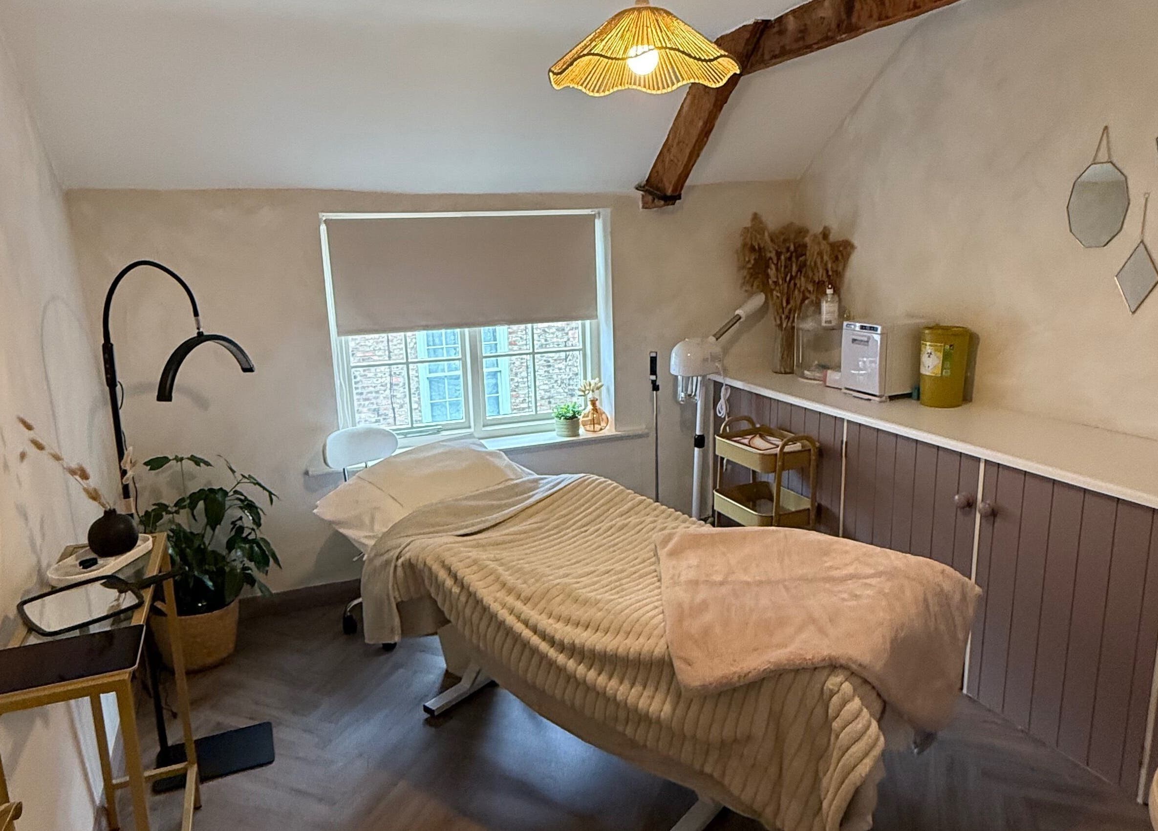 Relaxing treatment room at Bare and Glow Skin, Ripon, England, GB with warm decor and a treatment bed.