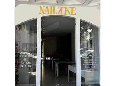 Вход в салон NailZone в Никосии, Лефкосия, Кипр, с современным дизайном и стеклянными дверями.