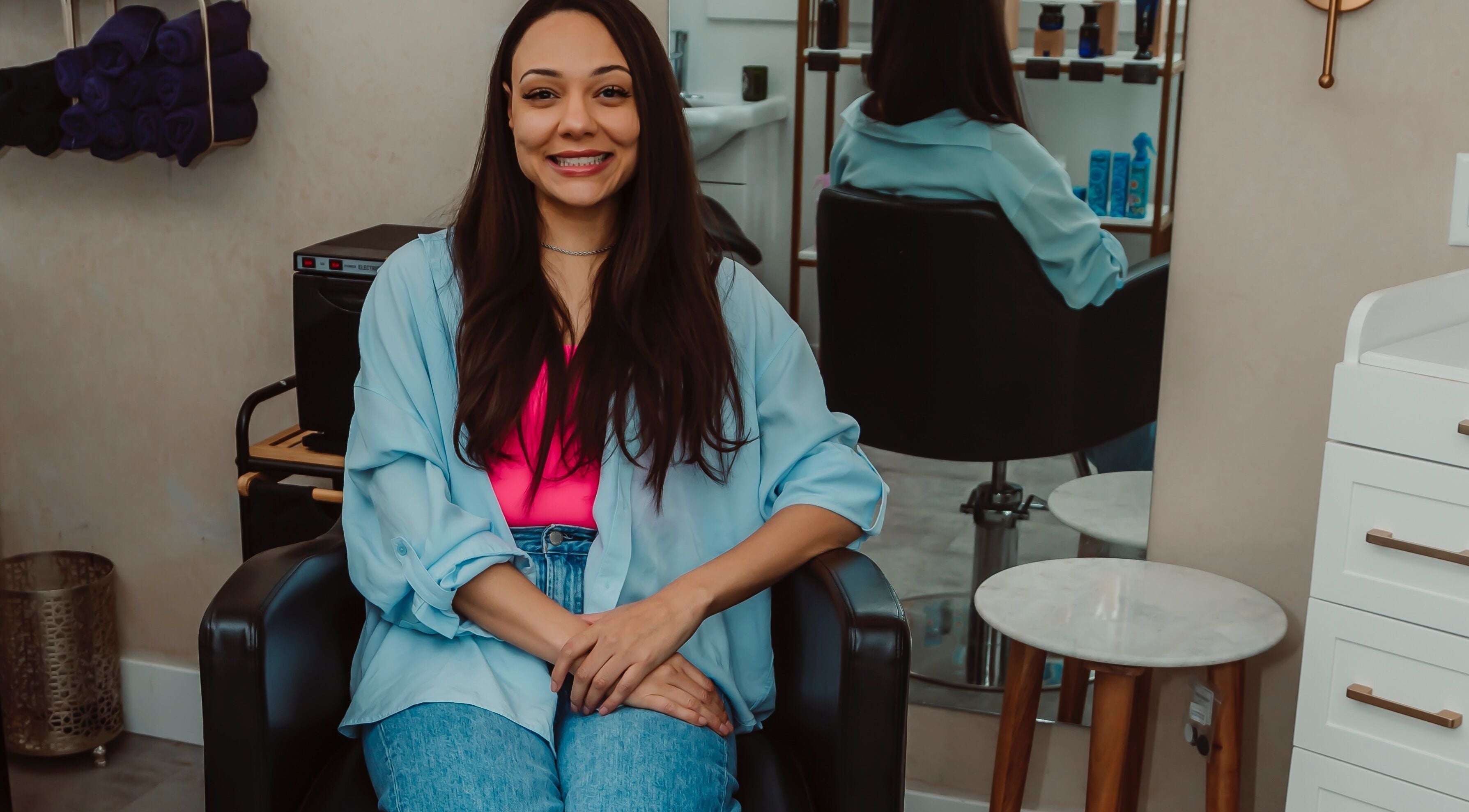 Happy client seated at Sanctioned Hair Salon in Kelowna, British Columbia, CA, showcasing chic style.
