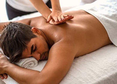 Man receiving a back massage at Serenique Massage Clinic in Clayton West, England, GB.