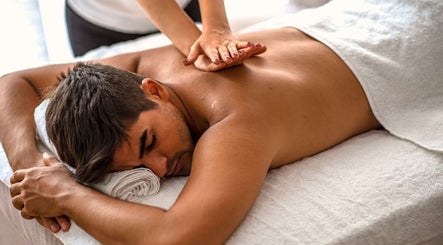 Man receiving a back massage at Serenique Massage Clinic in Clayton West, England, GB.