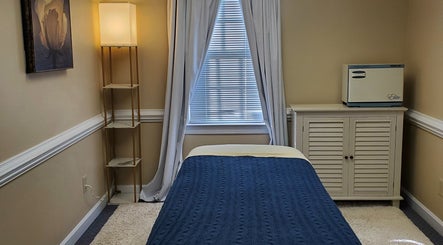 Tranquil massage room at Magnolia Massage Arts, Cary, North Carolina, US, featuring a cozy bed and soft lighting.