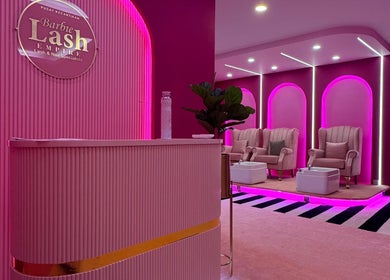 Luxurious interior of Barbie Lash Empire in Kuala Lumpur with plush seating and vibrant pink lighting.