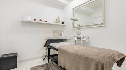 A tranquil treatment room at Junique Nails, Vigo, ES, featuring a relaxing massage table and a large mirror.