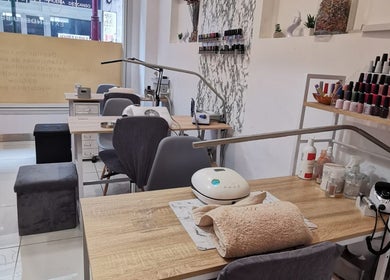 Mesa de servicio en Junique Nails, Vigo, ES, con herramientas de manicura y esmaltes exhibidos.