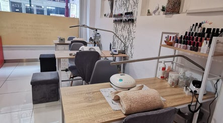 Mesa de servicio en Junique Nails, Vigo, ES, con herramientas de manicura y esmaltes exhibidos.
