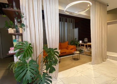 Relaxing lounge at Orenda Day Spa, Hobart, Tasmania, AU with cozy orange sofa and lush decor.