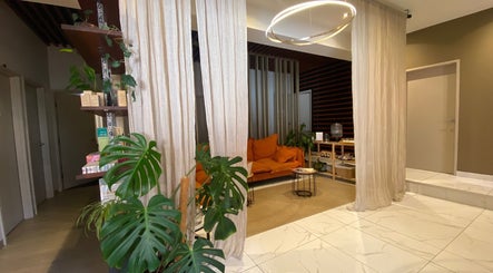 Relaxing lounge at Orenda Day Spa, Hobart, Tasmania, AU with cozy orange sofa and lush decor.