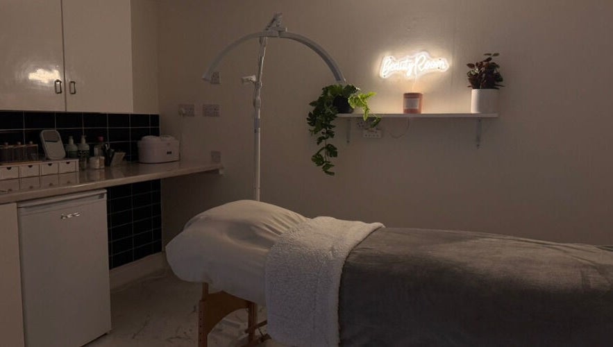 Relaxing treatment room at Simply Beauty, Ramsey, Ramsey, IM, featuring ambient lighting and cozy decor.