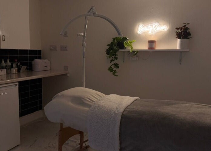 Relaxing treatment room at Simply Beauty, Ramsey, Ramsey, IM, featuring ambient lighting and cozy decor.