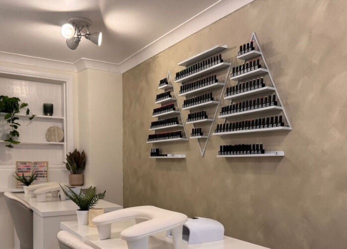 Simply Beauty nail polish display setup in Ramsey, Ramsey, IM, featuring sleek wall-mounted shelves.